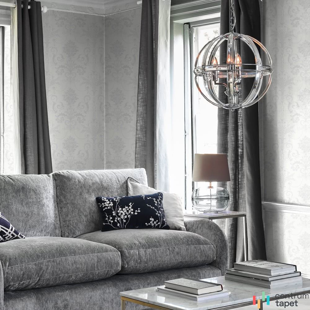 Laura Ashley 113382 za szarą sofą przy oknie i kulistej lampie wiszącej