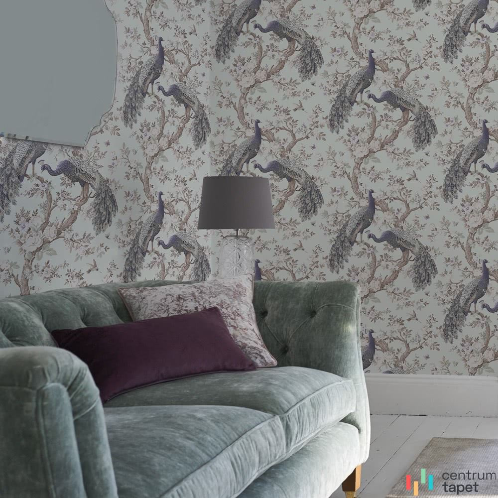 Tapeta Laura Ashley 113398 za zieloną sofą i ciemnofioletową poduszką