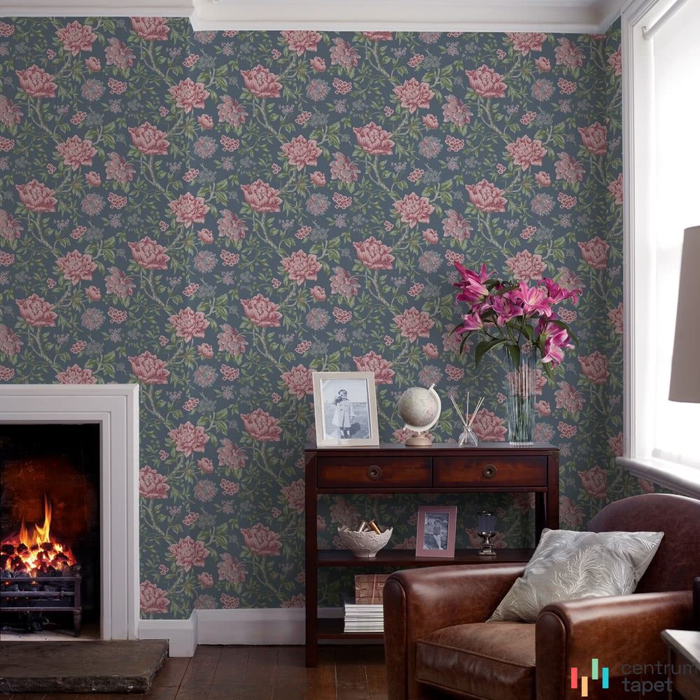 Laura Ashley 113407 za skórzanym fotelem i niską konsolą z kwiatami