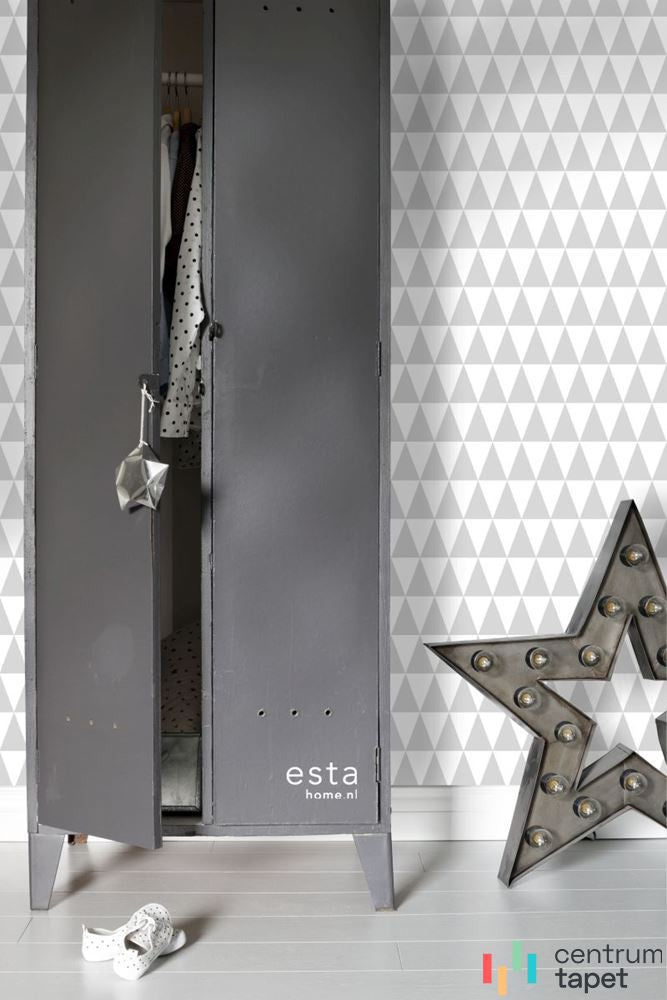 Tapeta w trójkąty obok szarej metalowej szafy i dekoracyjnej gwiazdy z kulistymi lampkami