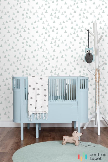 Biała tapeta w blade trójkąty za niebieskim łóżeczkiem